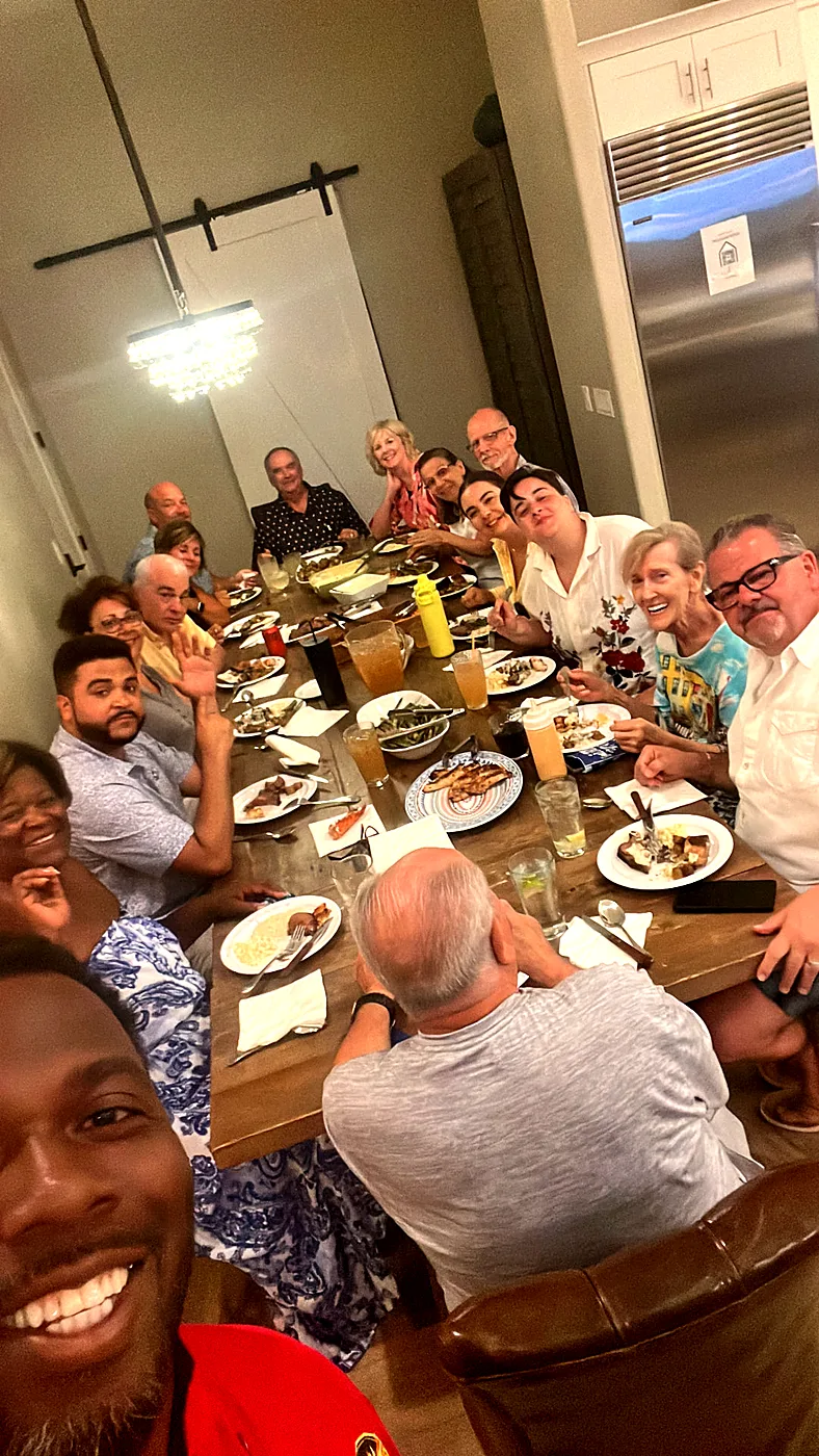 Chef Terry with a full family dinner table of smiling guests at a private home celebration
