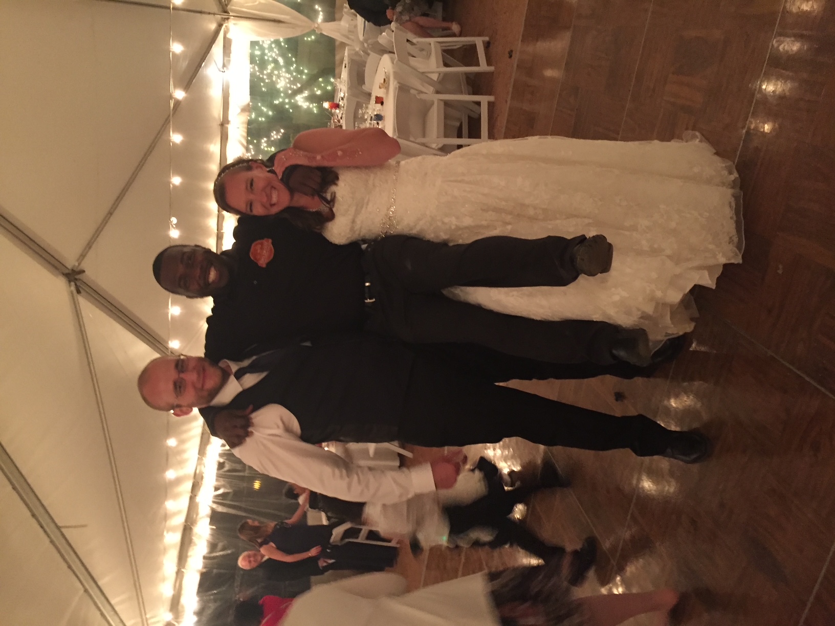 The BBQ Daddy dancing with bride and groom under tent string lights at a Phoenix Metro wedding