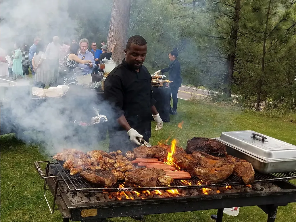 Live charcoal onsite grilling station with Chef Terry — signature Qfire Catering Wood-Fired BBQ experience