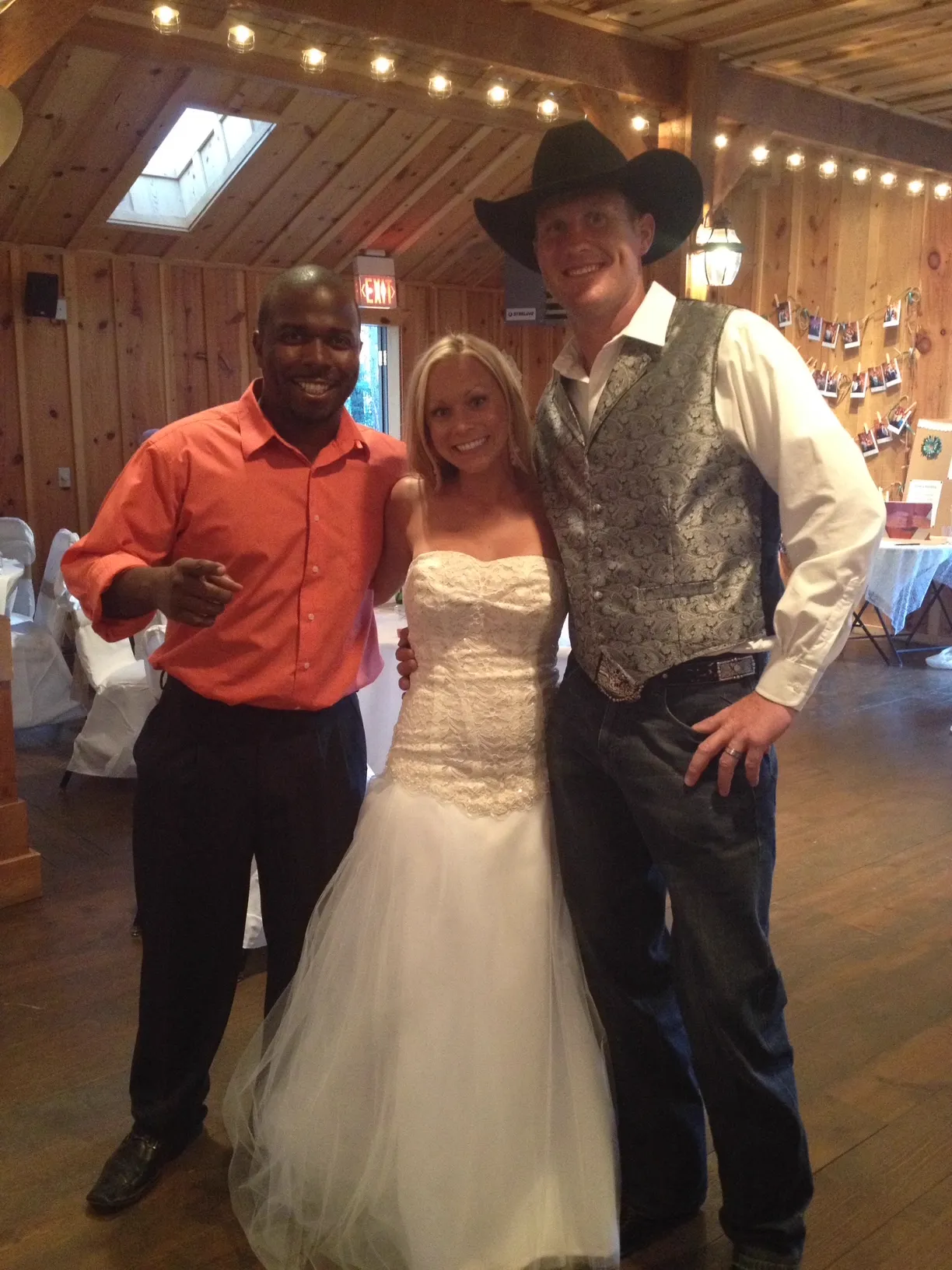 The BBQ Daddy with bride and cowboy groom at a rustic barn wedding reception