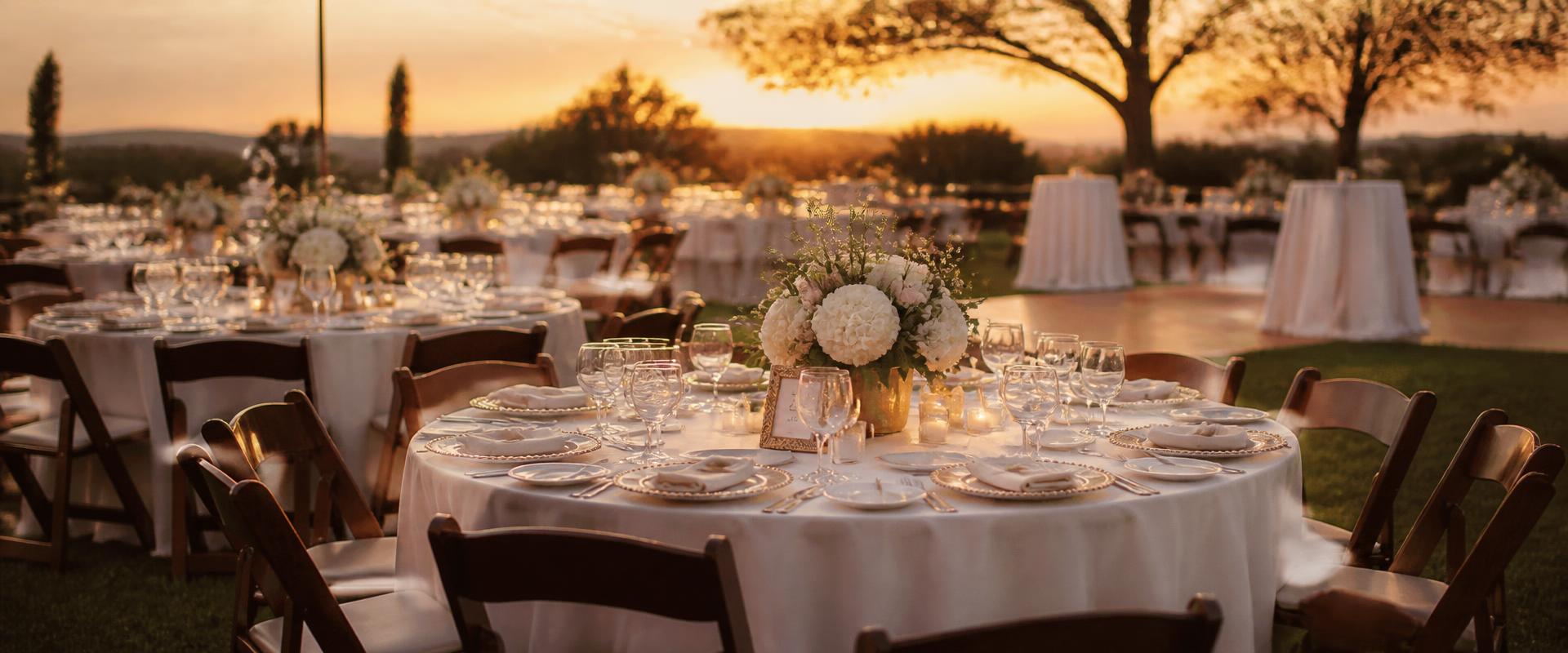 Formal outdoor reception tables with white linens, glassware and cherrywood chairs — rental equipment by TheBBQDaddy.com
