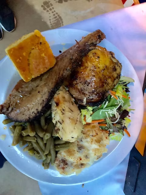Wood-fire catering buffet plate — sliced brisket, smoked chicken and house sides served family-style by Qfire Catering