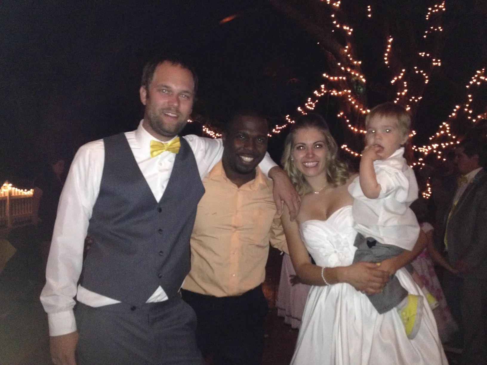 Chef Terry with bride, groom and flower girl under string lights at a Phoenix Metro wedding reception
