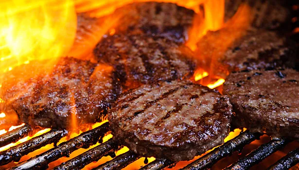 Premium one-third pound all-beef hamburger patties on the grill