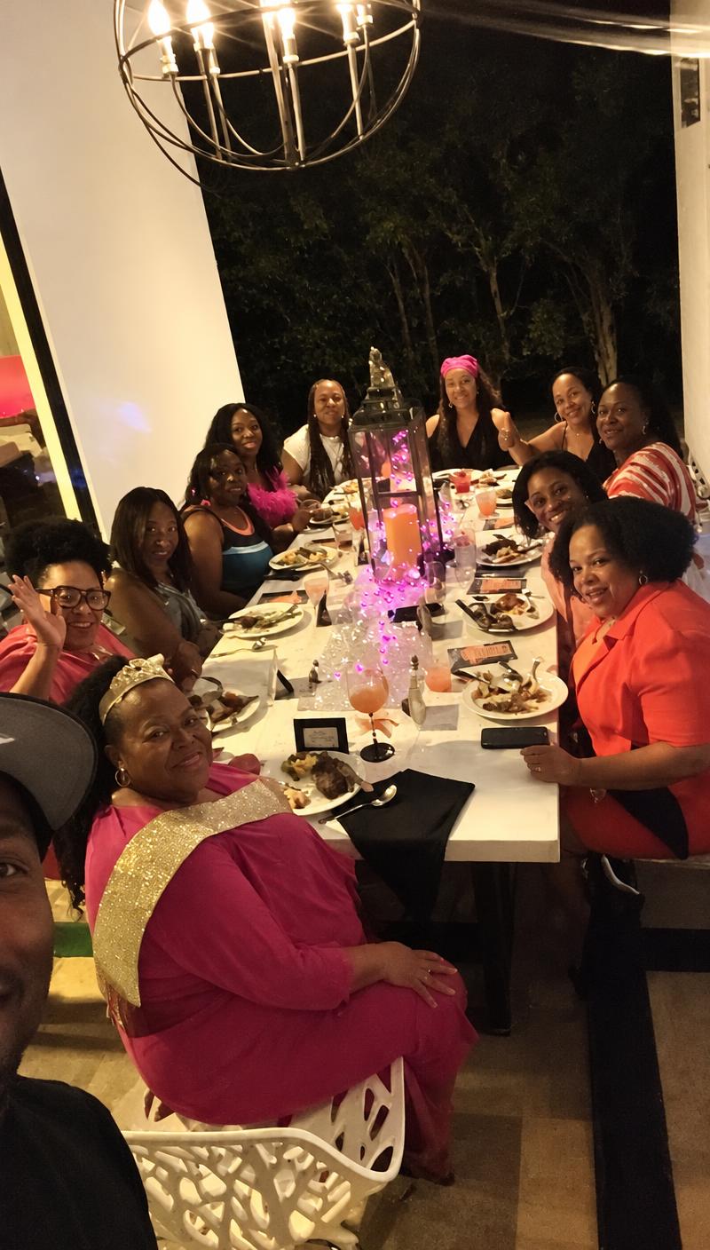 Guests in festive attire at a candlelit long-table birthday dinner